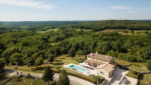 A two-story house with a swimming pool, surrounded by lush greenery and hills in the background. - Lovely home in Karojba with sauna (Karojba)