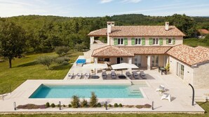 A two-story house with a swimming pool, outdoor seating, and a garden. - Lovely home in Karojba with sauna (Karojba)