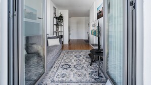A modern living room with a grey sofa, a patterned rug, and a TV stand. - GuestReady - Serene stay in Porto (Porto)