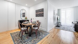 A modern dining area with a round table, six chairs, and a patterned rug. - GuestReady - Serene stay in Porto (Porto)