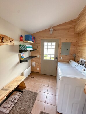 Convenient laundry facilities with a washing machine, drying rack, and storage for essentials.