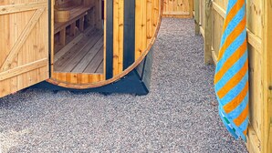 Uma sauna de madeira com uma placa indicando 'Sauna' e um aviso sobre superaquecimento.