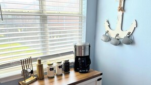 Eine Küchenarbeitsplatte mit Kaffeemaschine, Gläsern und Küchenutensilien.