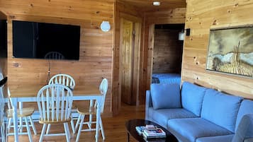 Un intérieur en bois avec un canapé, une table et des chaises.