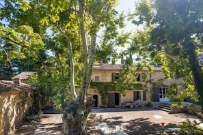Un bâtiment en pierre doté d’une cour intérieure, entouré d’arbres.