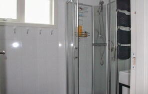 A glass-enclosed shower with a handheld showerhead and a wall-mounted faucet. - Awesome home in Matre with kitchen (Matre)