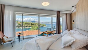 Ein Schlafzimmer mit einem großen Fenster, das einen herrlichen Blick auf einen See und Berge bietet.