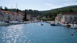 A marina with boats docked, surrounded by stone buildings with red-tiled roofs. - Amazing home in Lozisca with WiFi (Lozisca)
