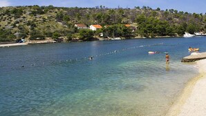 A coastal area with clear water, a sandy beach, and a hillside with buildings. - Amazing home in Lozisca with WiFi (Lozisca)