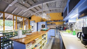 A modern kitchen with a wooden island, blue cabinets, and a stone wall.