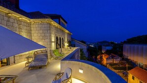 Un edificio de piedra con balcón y zona de estar al aire libre.