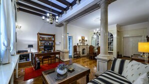 Un salón amplio con chimenea, televisor y estantería.