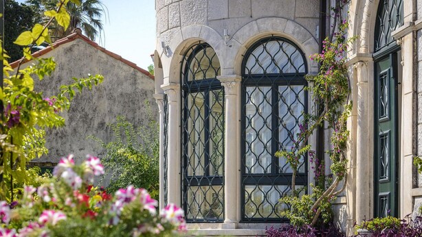 Un edificio con ventanas de arco y fachada de piedra.