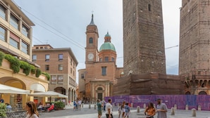 Une place historique, avec une église imposante, une haute tour et un bâtiment en construction.