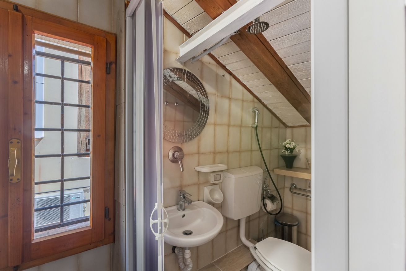 Une salle de bain avec une porte en bois, un lavabo, des toilettes et une douche.