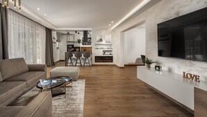 Un salon moderne avec un canapé, une table basse et un téléviseur fixé au mur.