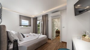 Une chambre à coucher moderne avec un lit, une table de chevet et un téléviseur fixé au mur.