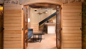A narrow wooden doorway leading into a room with a staircase, a small table, and a blue chair. - Villa Bea (Dvor Pitve Villa B) (Jelsa)