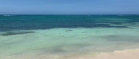 Rannalla, aurinkotuoleja, rantapyyhkeitä