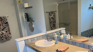 Un baño moderno con dos lavamanos, un espejo grande y un mueble de tocador con cajones.