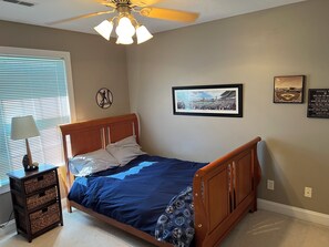 Cozy bedroom with a comfortable bed, nightstand, and wall-mounted shelf.