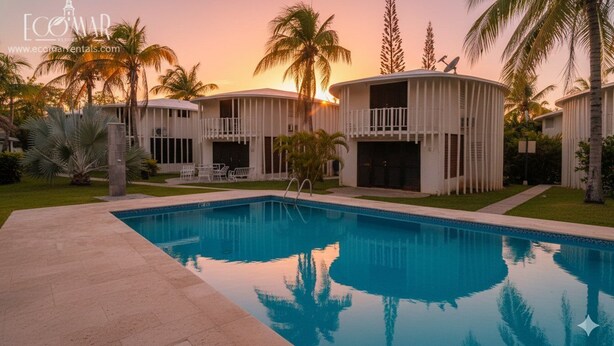 A resort with a swimming pool, palm trees, and a sunset.