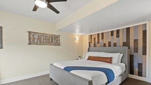 A bedroom with a bed, a ceiling fan, a wall-mounted light, and a decorative sign. - WindnSea Beach Perfection - Walk to Beach, Pet Friendly & Parking! (La Jolla)