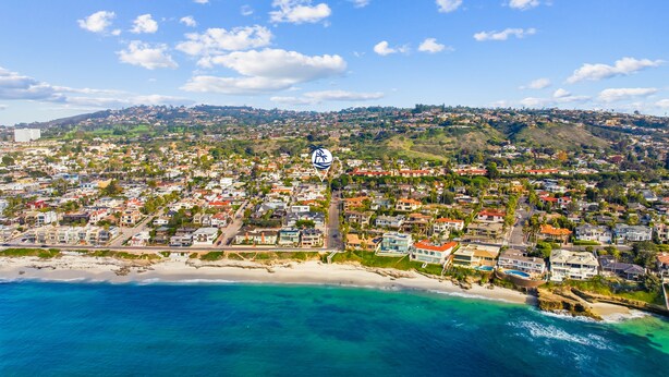 An aerial view of a coastal town with a beach, residential areas, and a logo of a hotel chain. - WindnSea Beach Perfection - Walk to Beach, Pet Friendly & Parking! (La Jolla)