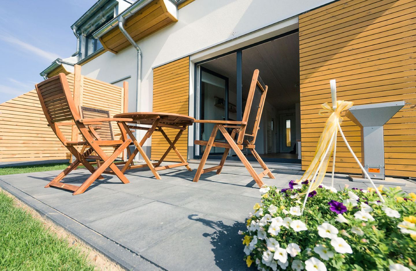 Un espace extérieur aménagé avec des meubles en bois et une composition florale.