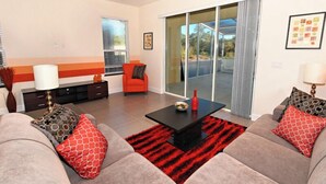 Una sala de estar moderna con un conjunto de sofá, una mesa de centro y un tapete rojo y negro.