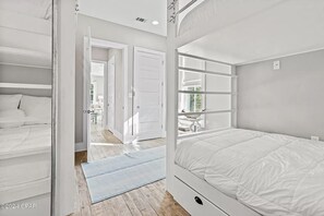 Een slaapkamer met een stapelbed, een inloopkast en uitzicht op een eetgedeelte.