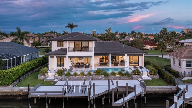 Ein zweistöckiges Haus mit einer großen Terrasse und einem Schwimmbad.