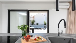 Una cocina moderna con estufa integrada, un lavamanos y una tabla de cortar con productos frescos.