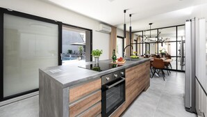 Una cocina moderna con una isla grande, horno empotrado y un comedor con vistas al exterior.