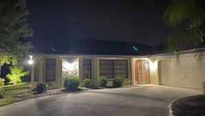 Uma casa com garagem, entrada com acesso por calçada e boa iluminação.