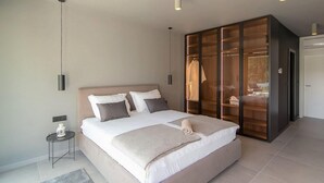 A modern bedroom with a large bed, a walk-in closet, and a small bedside table. - Cozy home in Rovinjsko Selo with sauna (Rovinjsko Selo)