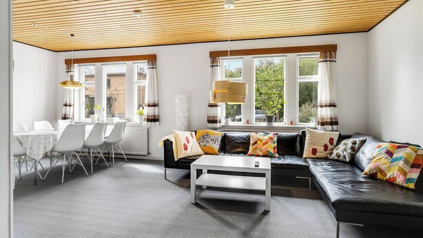 A modern living room with a sofa, coffee table, and dining area. - Cozy house close to Lalandia and Rødby Harbour (Rødby)