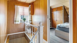 A wooden interior with a staircase, a bed, and a wardrobe. - Cozy house close to Lalandia and Rødby Harbour (Rødby)