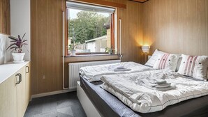 A bedroom with a bed, bedside table, window, and a view of the outside. - Cozy house close to Lalandia and Rødby Harbour (Rødby)