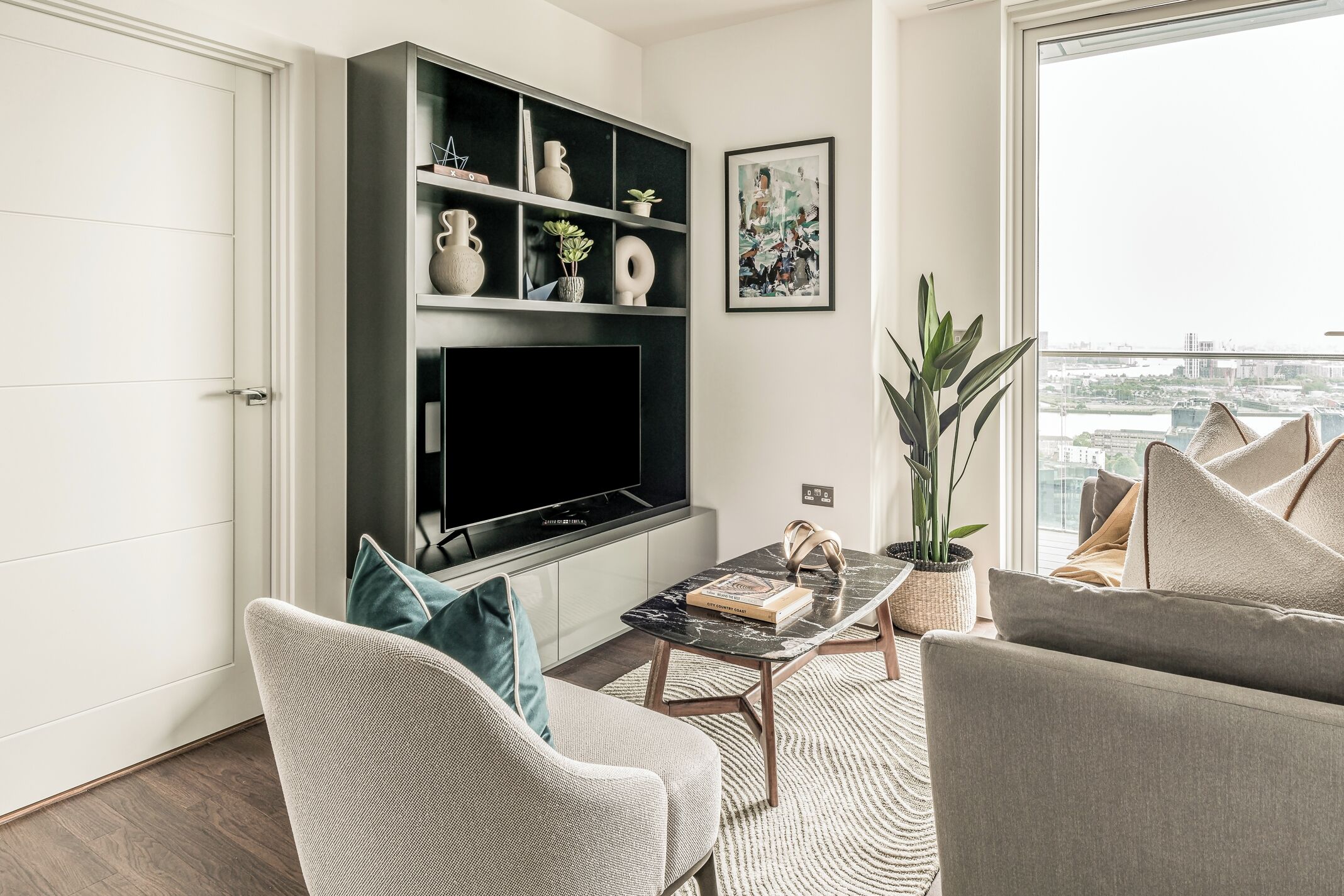 Una sala de estar moderna con un televisor de pantalla plana, una mesa de centro y asientos cómodos.