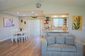 Relax in this stylish living space with a sofa, dining area, and kitchen.