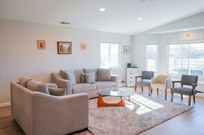 Relax in this stylish living room with a large sofa, two armchairs, and a coffee table.