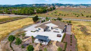 A two-story house with a covered patio, a fenced yard, and a hilly landscape in the background. - Newly remodeled 4-bedroom, 3-bathroom home with jacuzzi close to downtown Paso (Paso Robles)