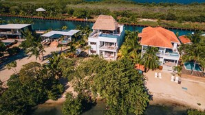 Eine Luftaufnahme eines Resorts mit mehreren Gebäuden, einem Swimmingpool und einem Strand.