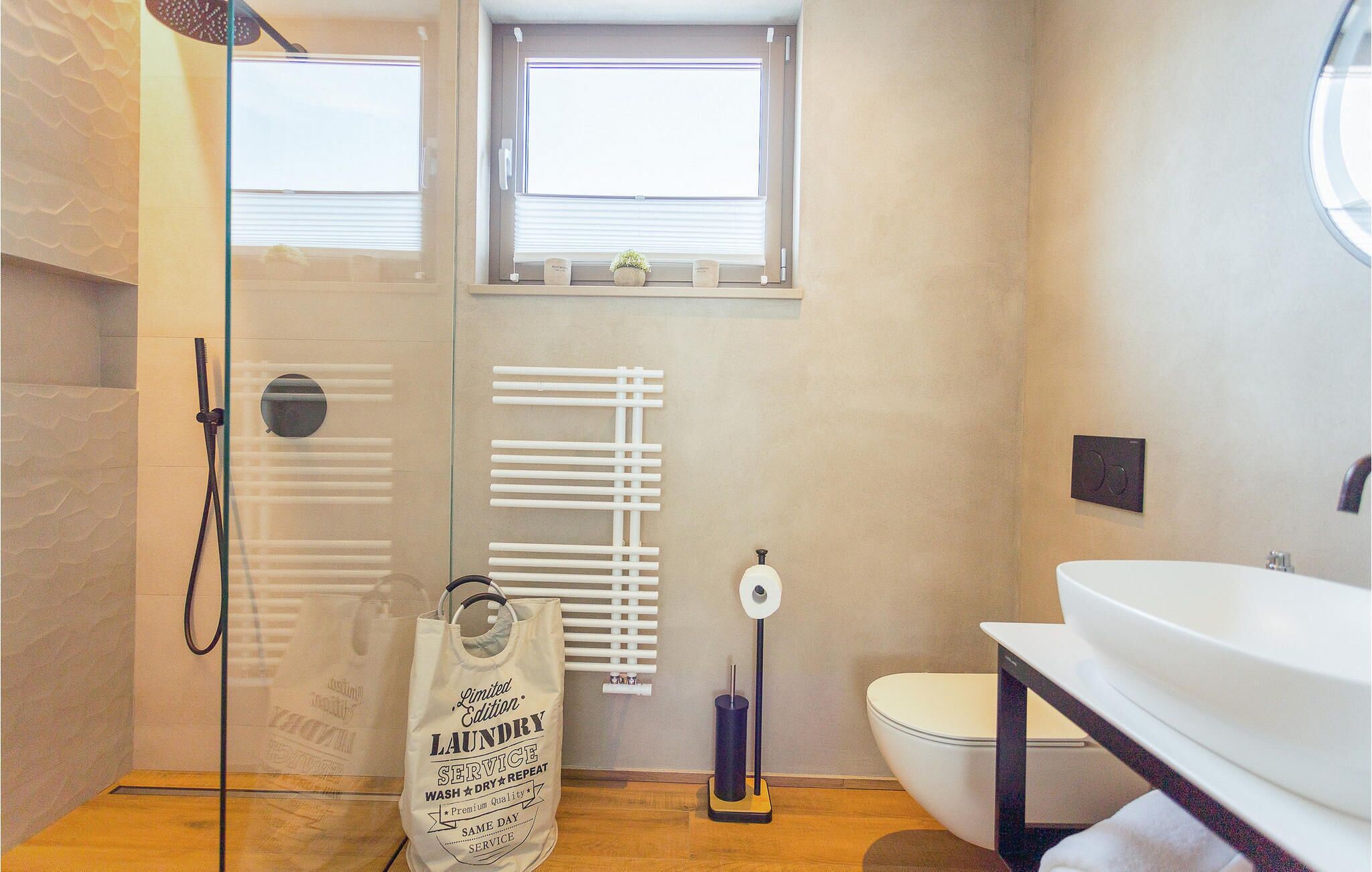 A modern bathroom with a glass shower enclosure, a toilet, and a sink.