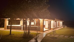 A modern building with a covered patio area, a stone facade, and a well-maintained lawn. - Llano Grande (Rionegro)