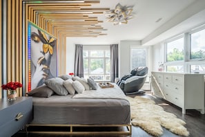 Ein modernes Schlafzimmer mit Bett, Schreibtisch und großem Fenster.