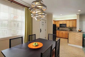 Enjoy meals in this kitchen and dining area, featuring a dining table and a well-equipped kitchen with a refrigerator and microwave.