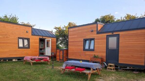 Une rangée de cabanes en bois, dotées d’un toit plat, chacune ayant une fenêtre et une porte.