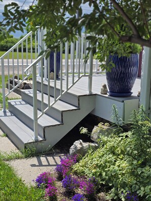 A set of outdoor stairs leading to a porch with a large blue planter.
